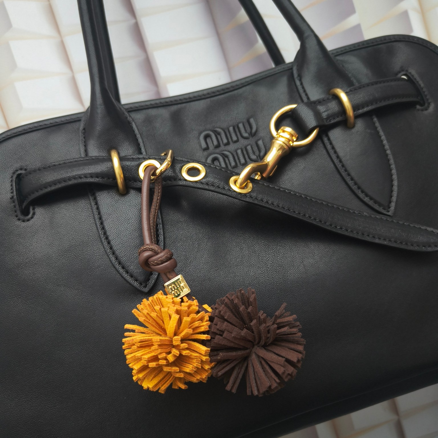 Luxury designer bag hangings Bold playful Soft leather Mini Wood logo Wax-coated cotton cord Detachable metal crochet
